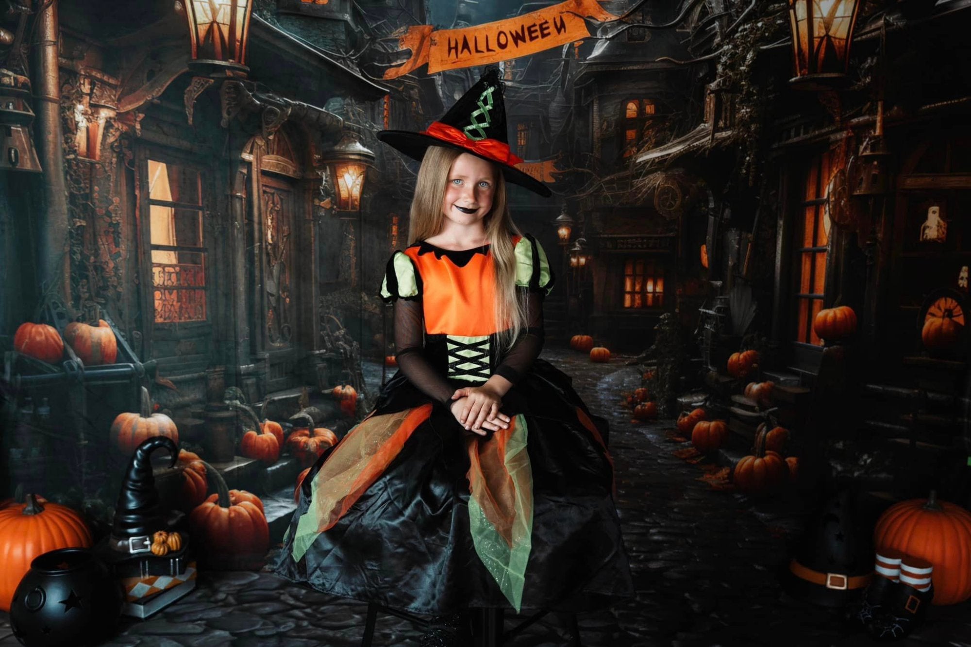 Une petite fille en costume de sorcier se tient dans la rue sur fond d'Halloween
