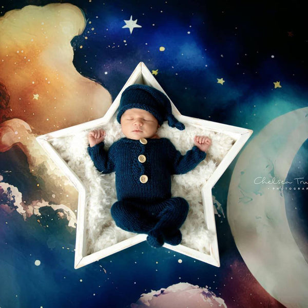 Bébé couché dans une étoile à cinq branches sur fond de ciel étoilé de nuit bleue